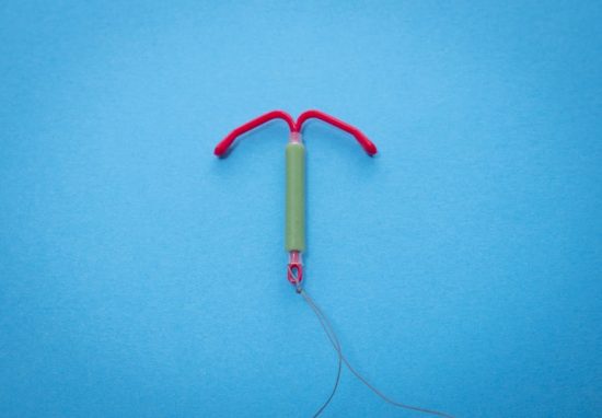 IUD lying down on a blue background