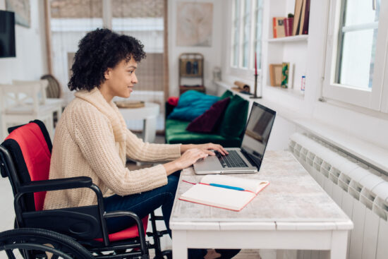 Young African American businesswoman in a wheelchair working online from home.